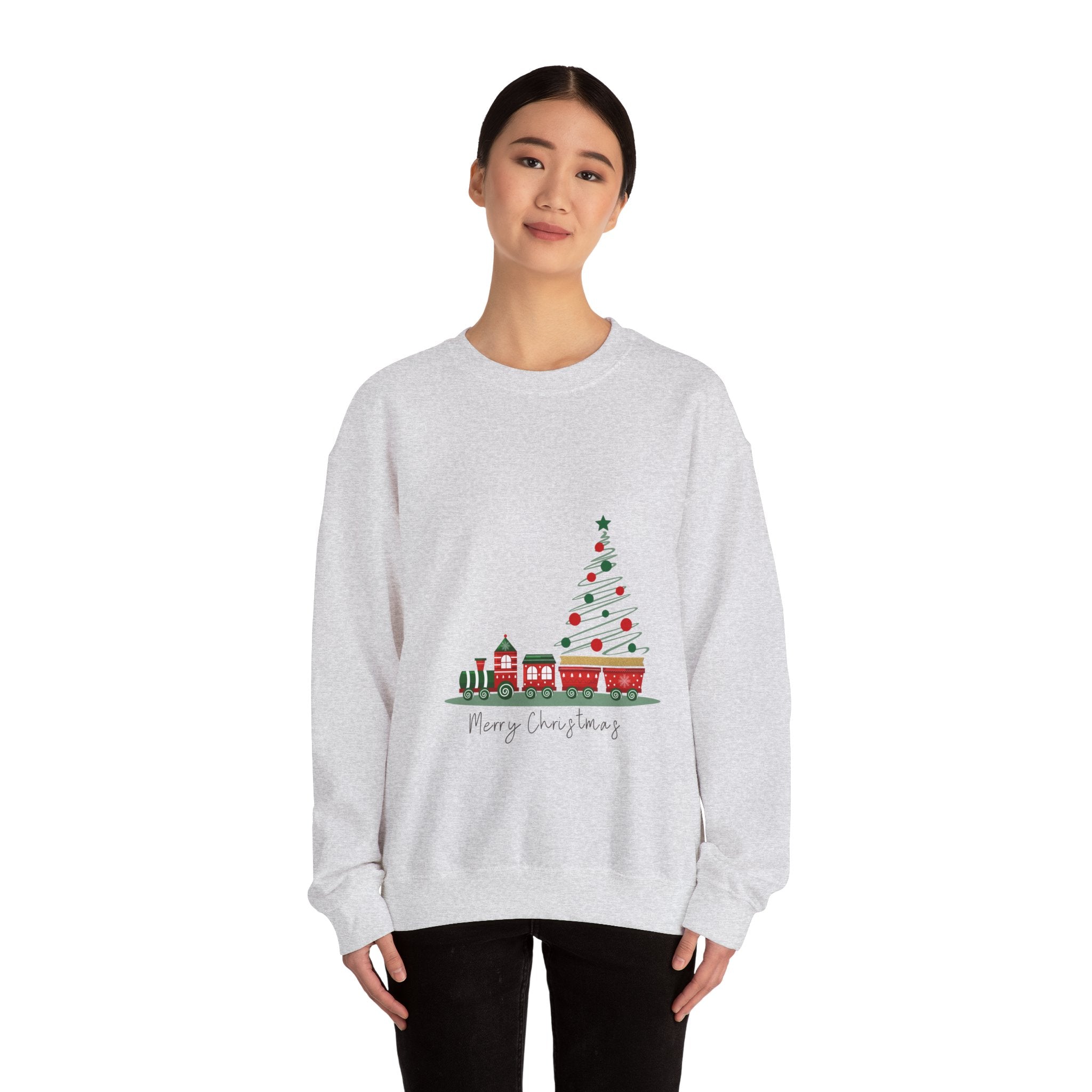 Person wearing a gray sweatshirt with a Christmas tree and train design on a white background