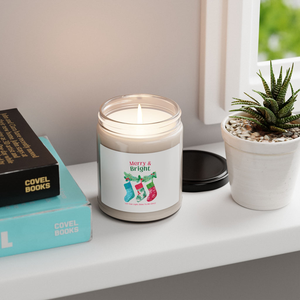 Candle with a 'Merry & Bright' label on a shelf with books and a plant
