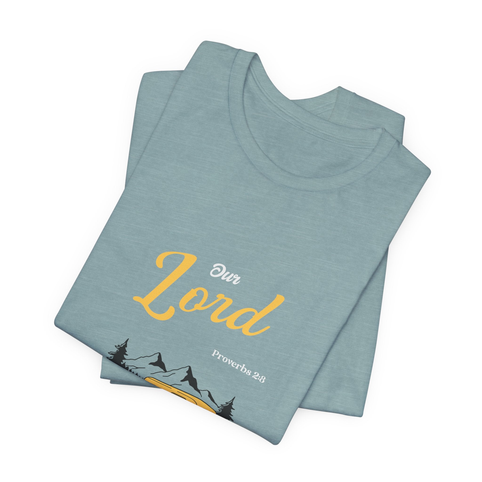 Folded light blue t-shirt with 'Our Lord' text and mountain design on a white background