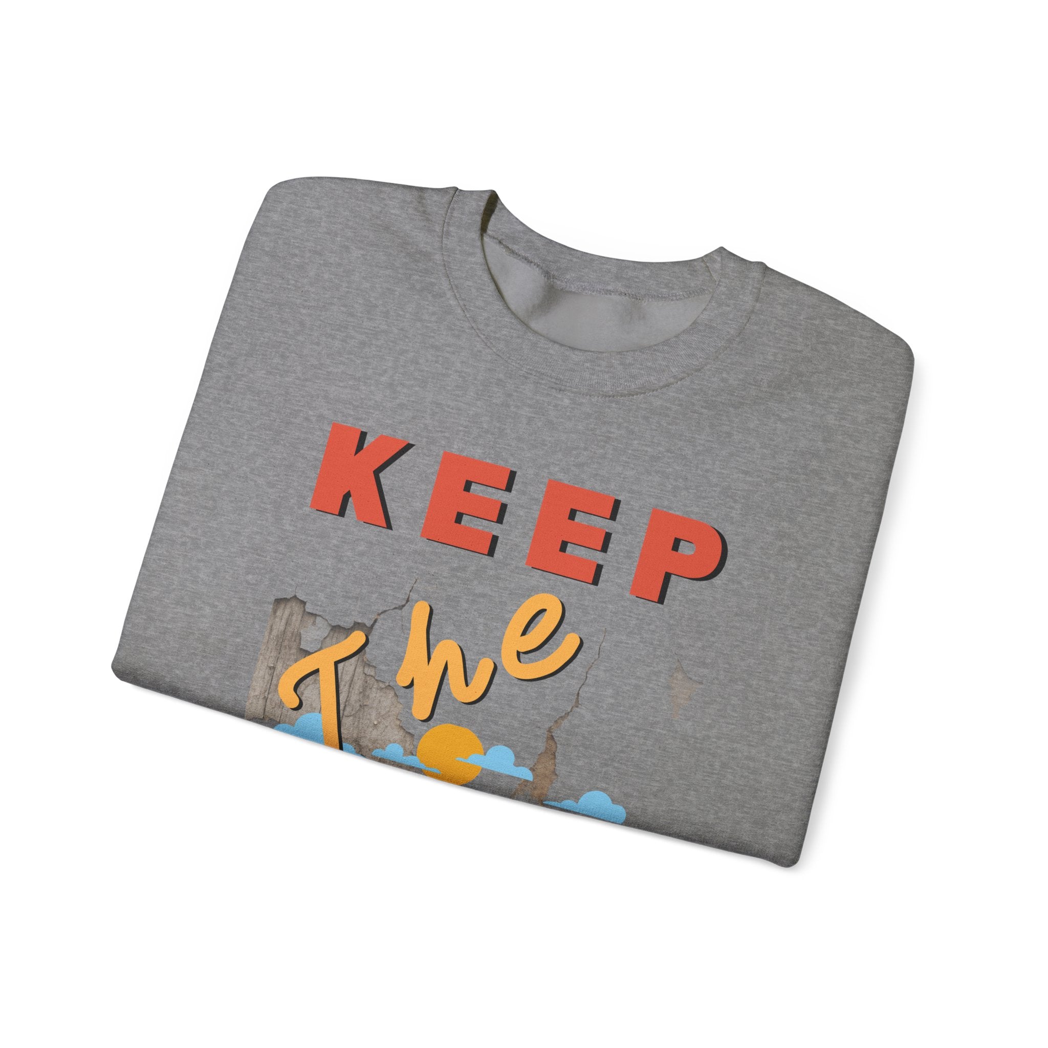 Folded gray t-shirt with colorful text and graphics on a white background