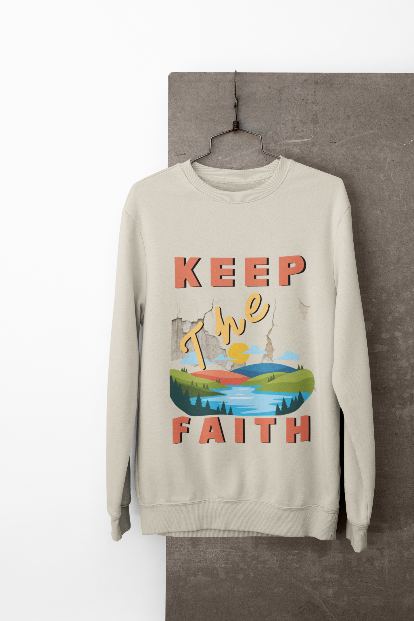 Beige sweatshirt with 'Keep The Faith' graphic design on a hanger against a neutral background