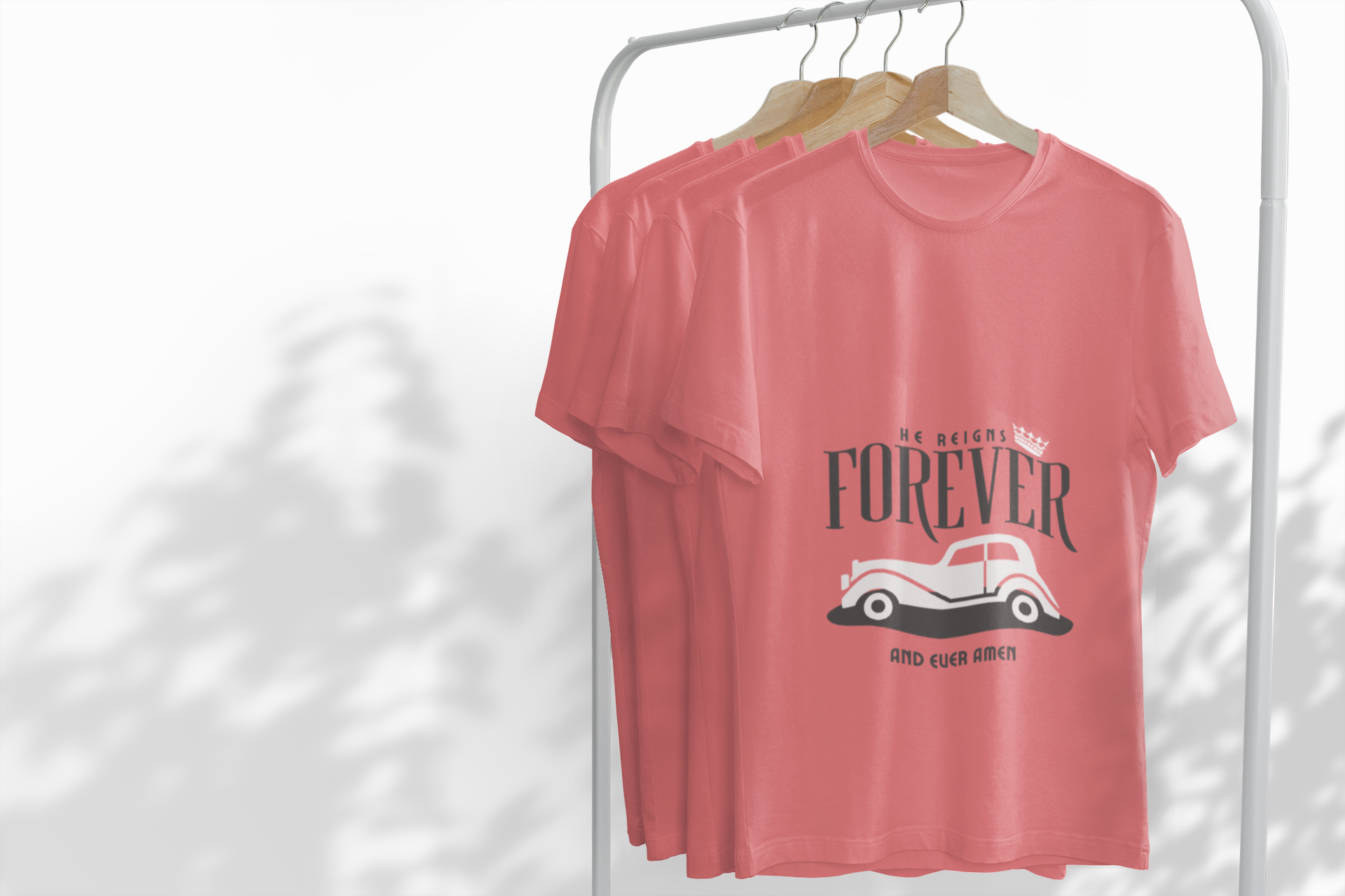 Pink t-shirt with graphic design and text on a white rack