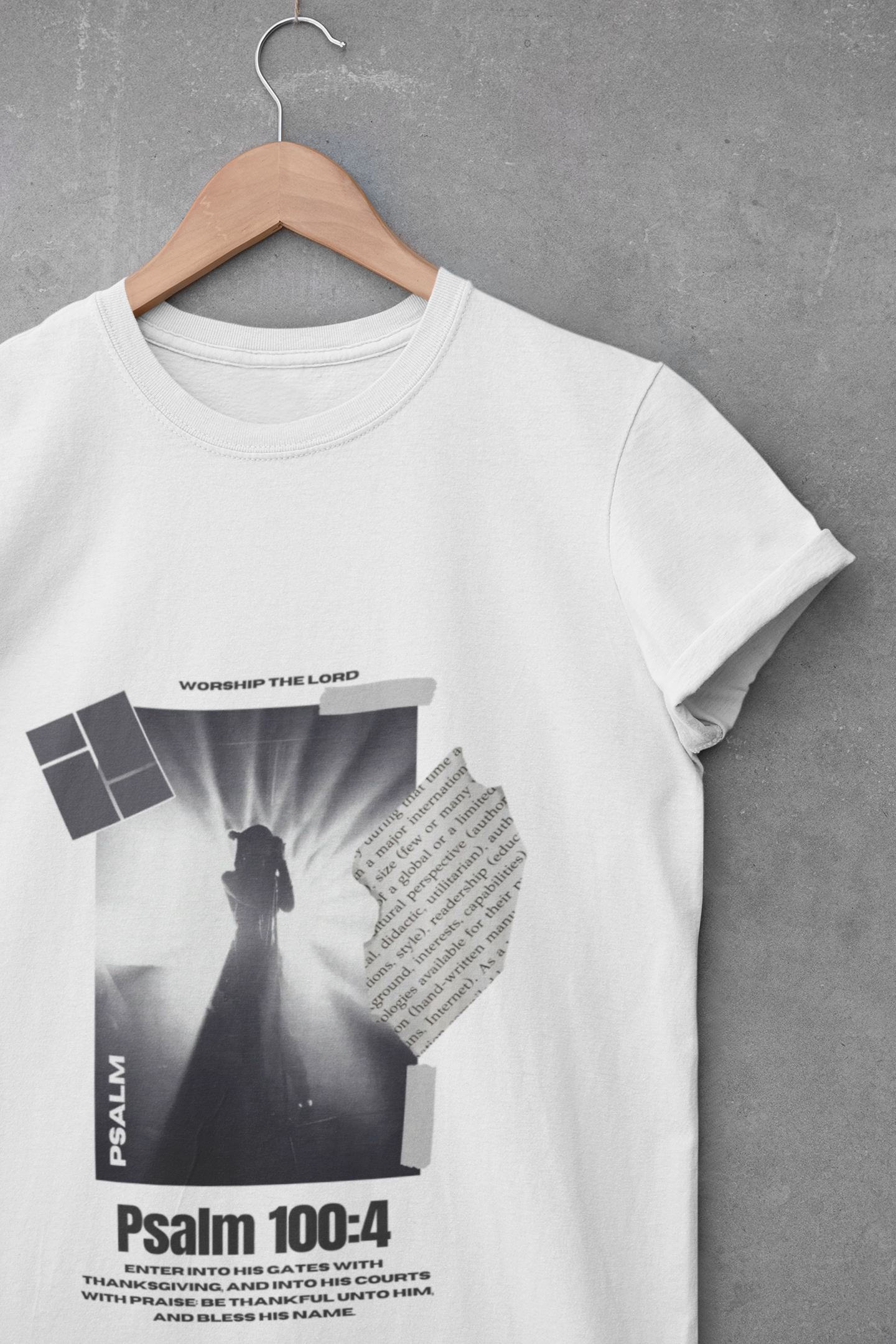 White t-shirt with black and white graphic design on a hanger against a gray background