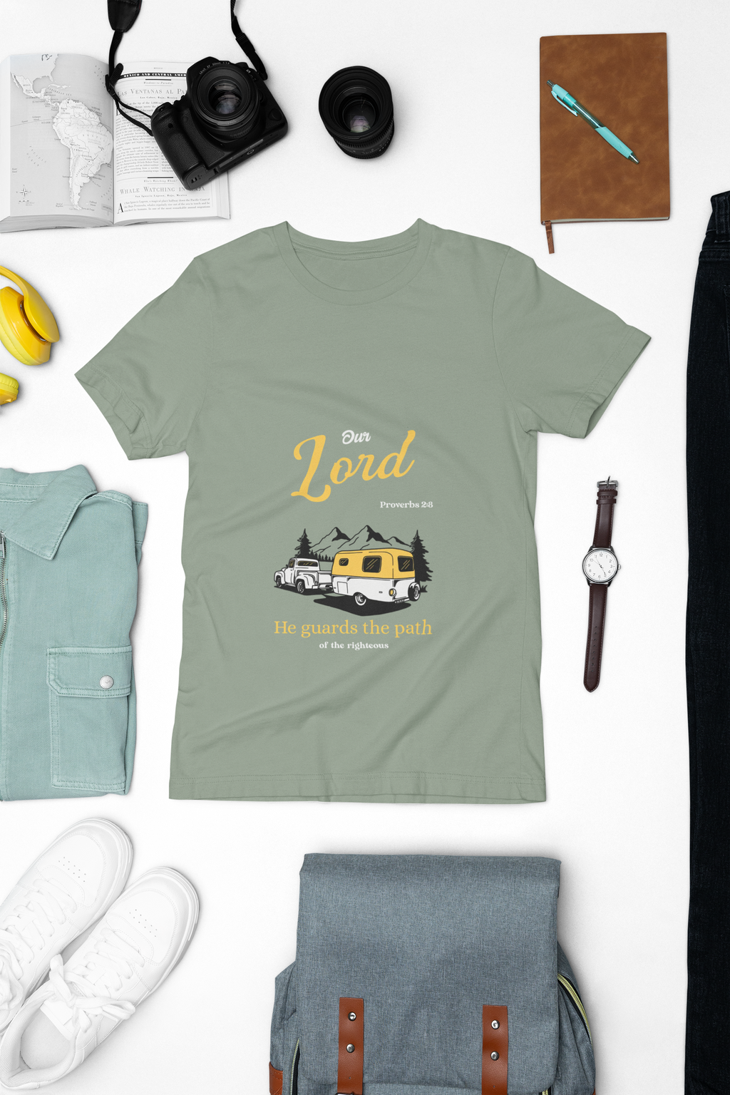 Green t-shirt with graphic design on a white background with accessories around