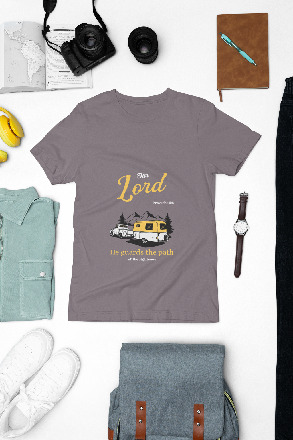 purple t-shirt with graphic design on a white surface with accessories around