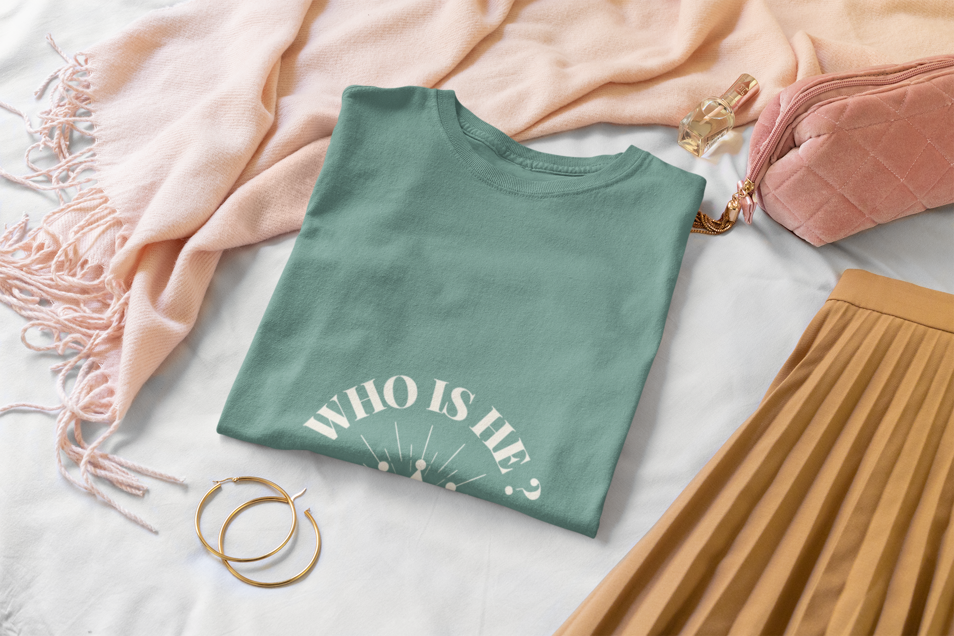 Green t-shirt with 'WHO IS He?' text on a bed with pink blanket and brown skirt.