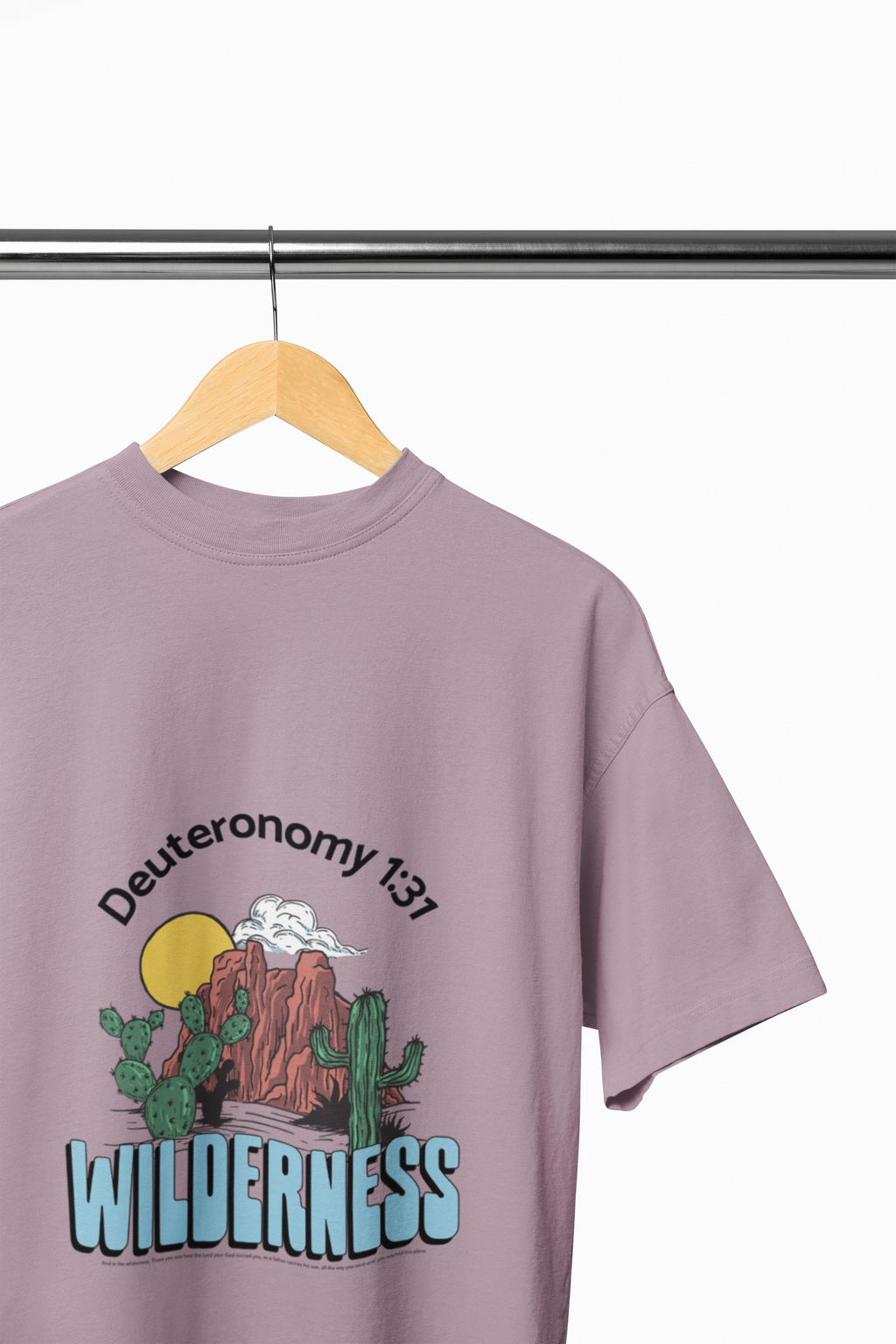 Purple t-shirt with desert graphic and text on a hanger against a white background