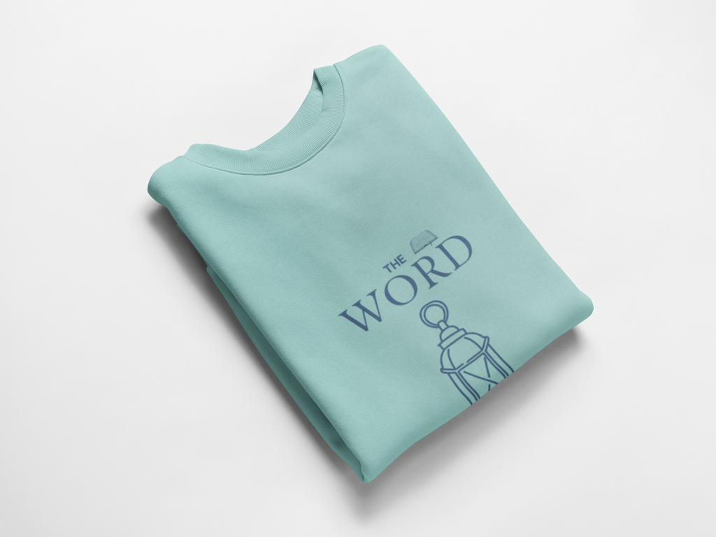 Folded light blue sweatshirt with 'The Word' text and graphic on a white background