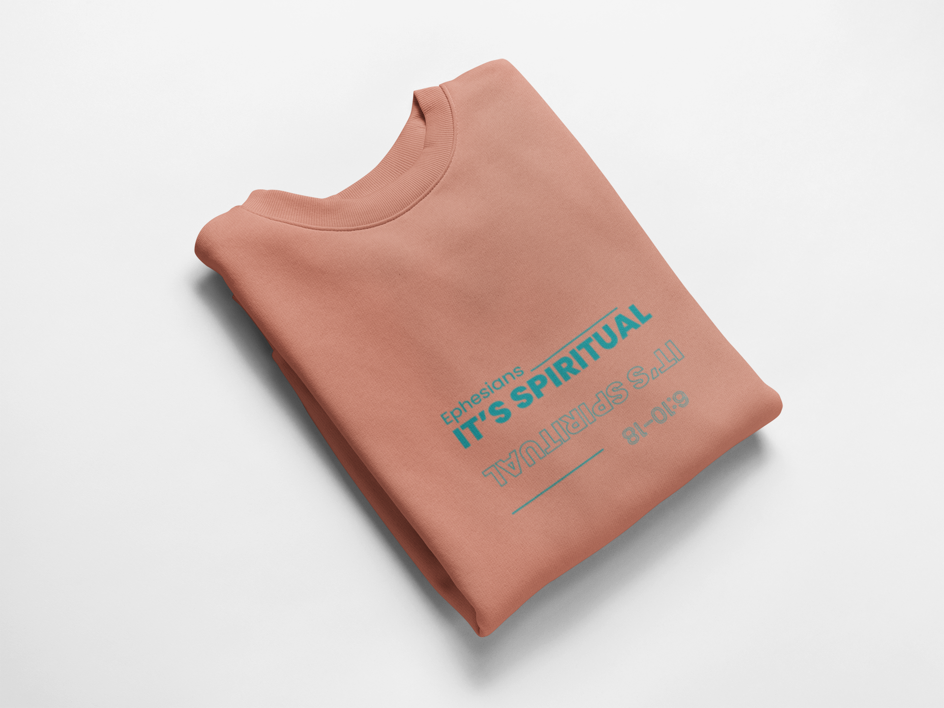 Folded coral sweatshirt with text on a white background