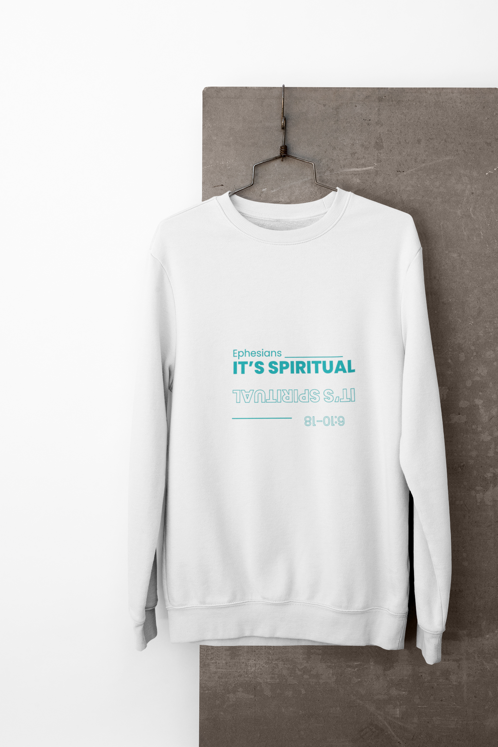 White sweatshirt with text on a gray surface