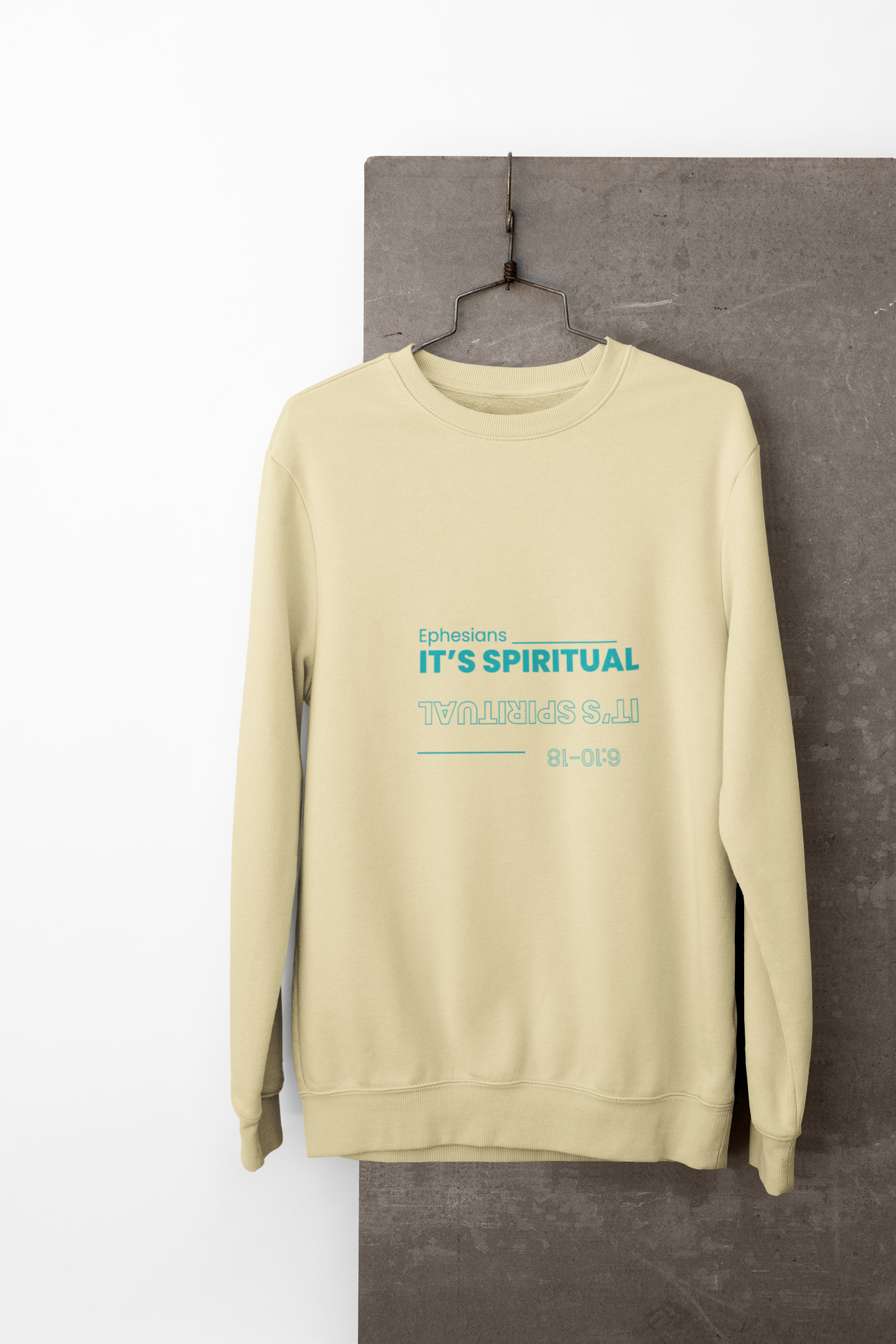 yellow sweatshirt with text on a gray surface