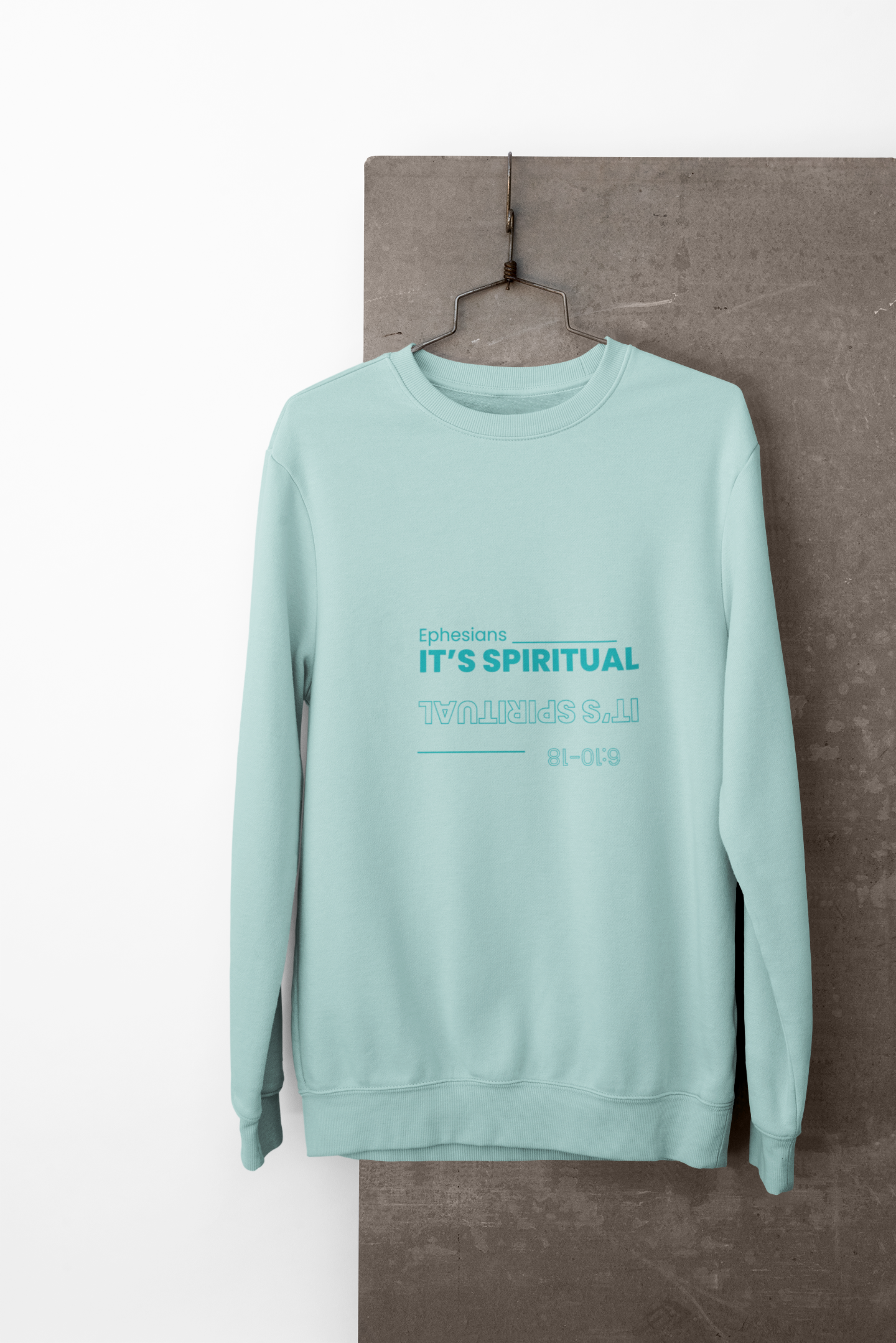 Mint green sweatshirt with text on a hanger against a white background