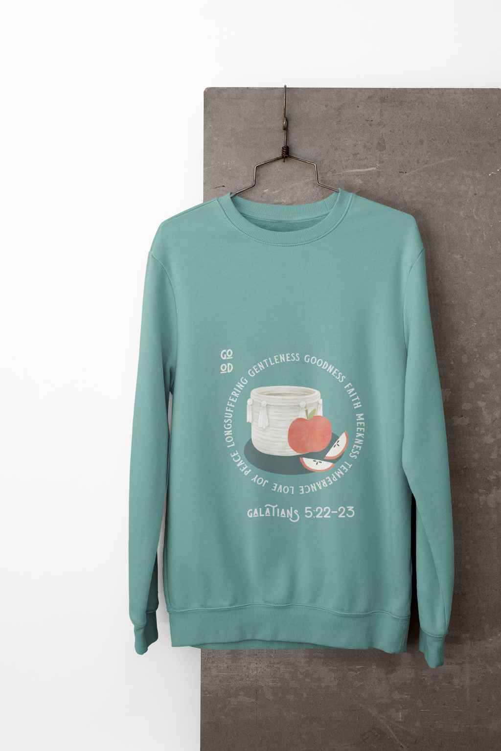 Teal sweatshirt with a graphic design on a hanger against a white background