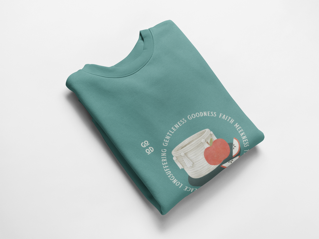 Folded teal sweatshirt with graphic design on a white background