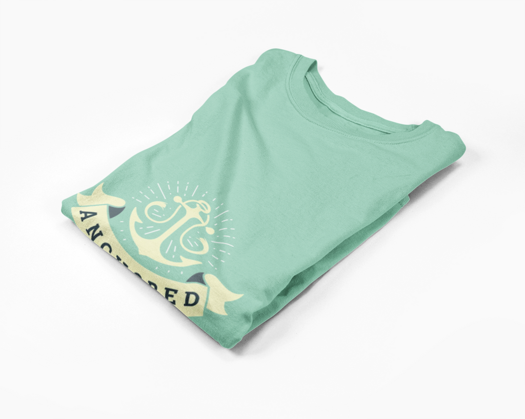 Folded mint green long-sleeve t-shirt with yellow anchor graphic and text on a white background