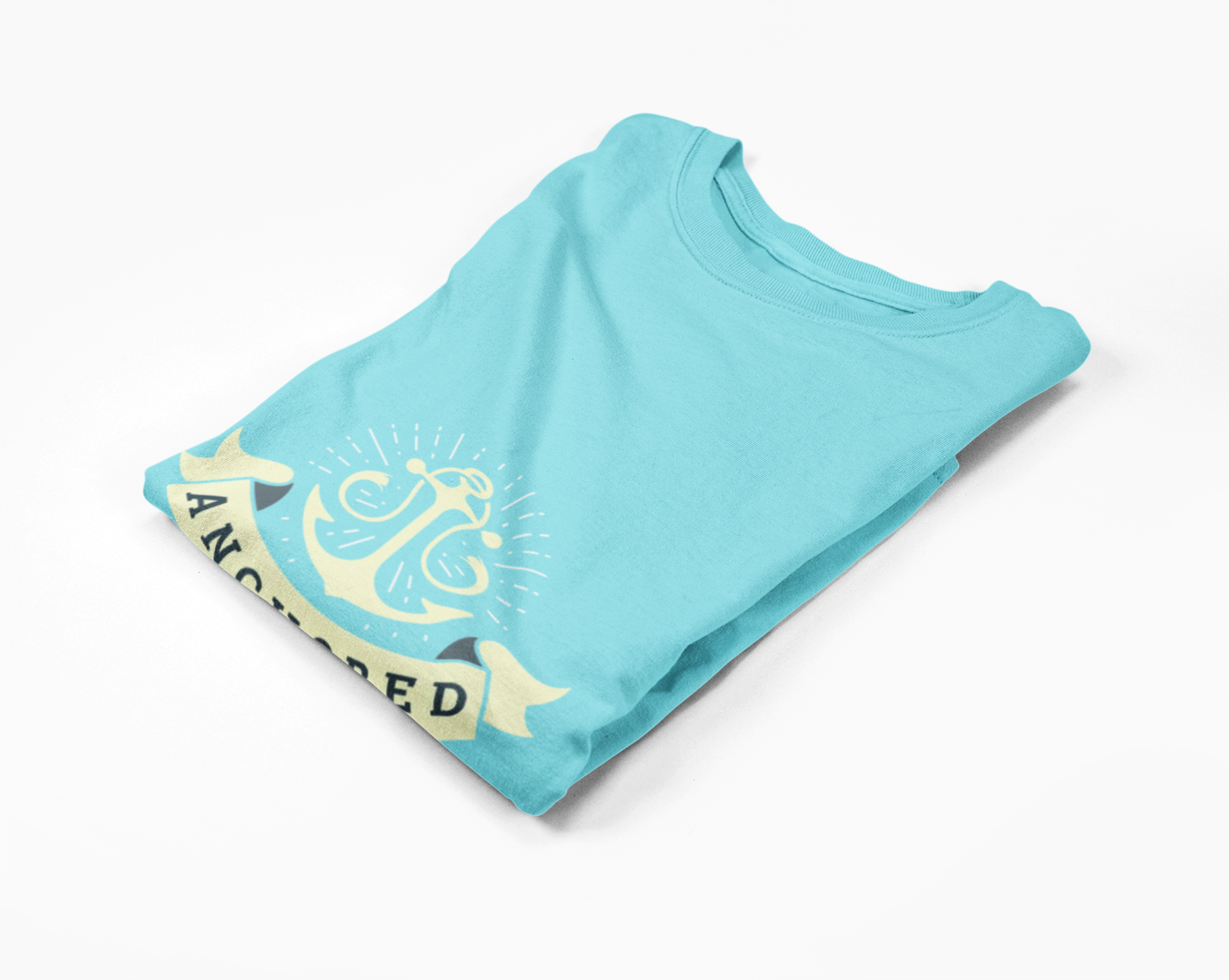 Folded lagoon blue t-shirt with anchor graphic and 'Anchored' text on a white background