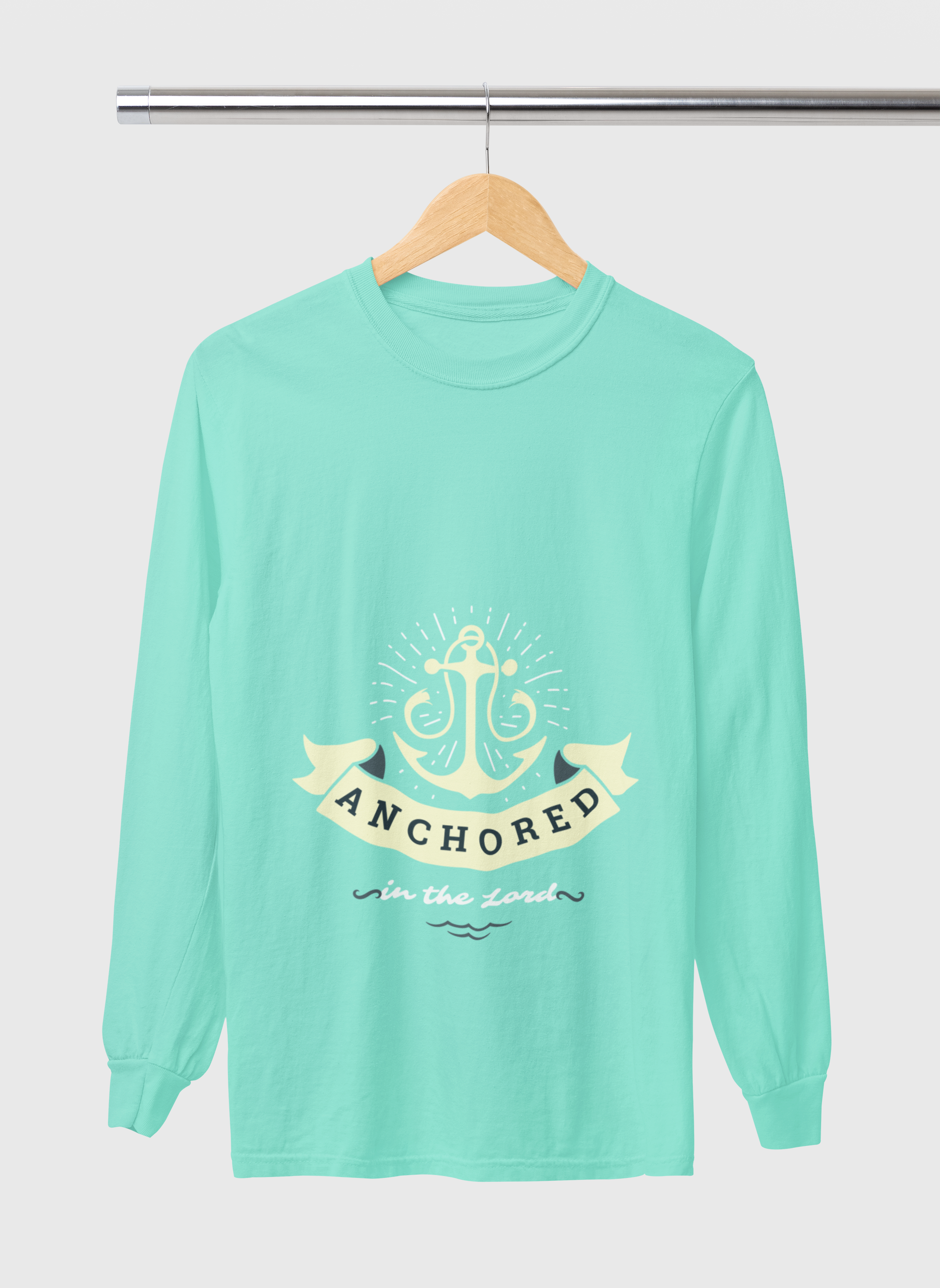Mint green long-sleeve shirt with anchor design and text on a hanger against a white background