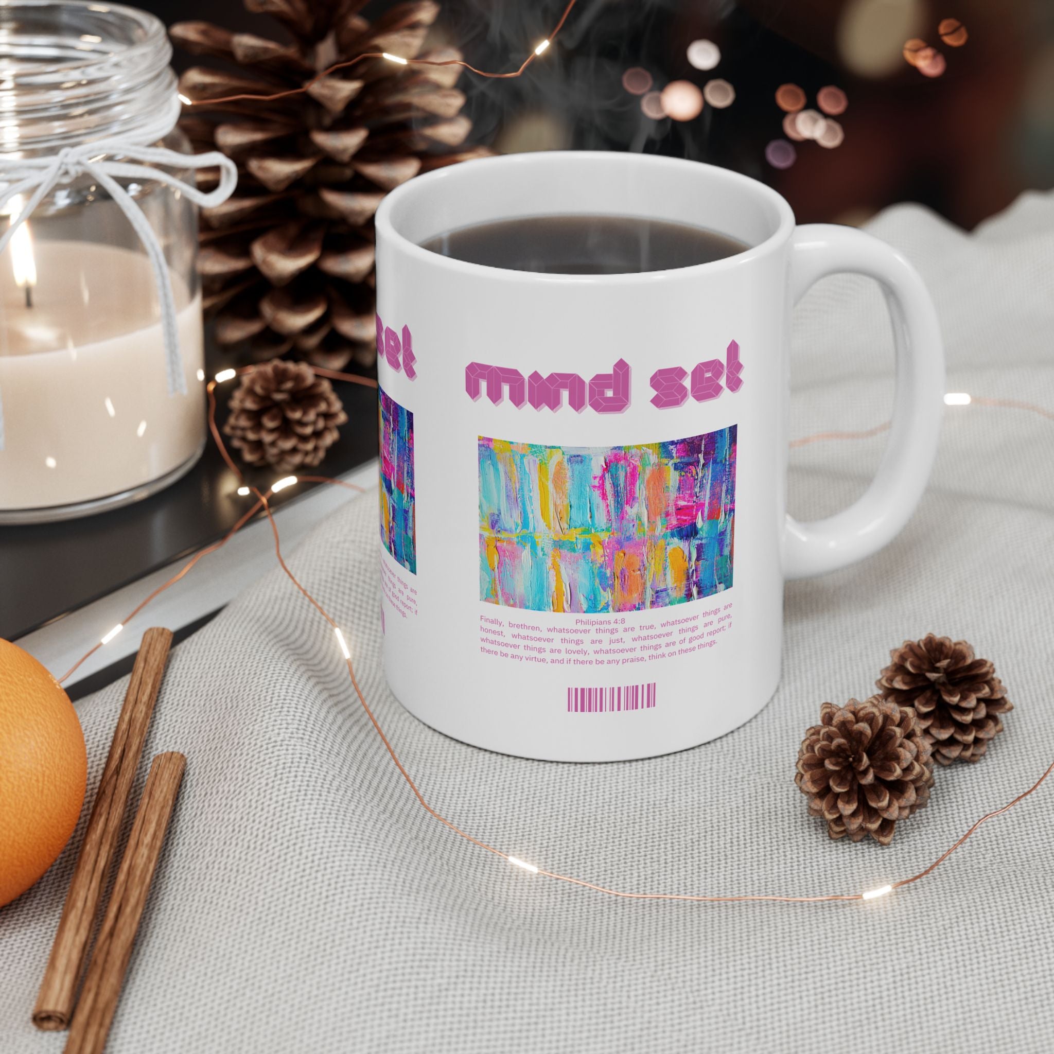 White mug with colorful text design on a table with decorative items