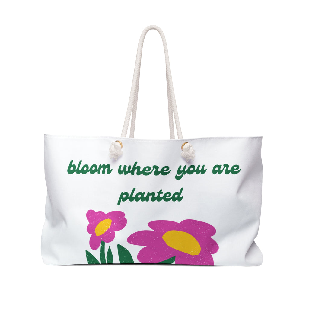 White tote bag with pink flowers and green text on a white background