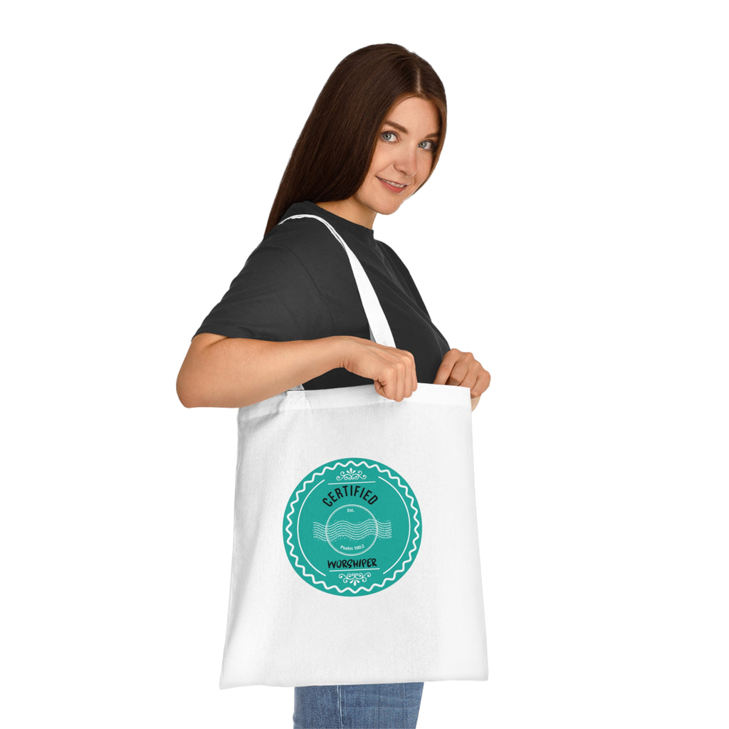 Woman holding a white tote bag with a green logo and text on a white background