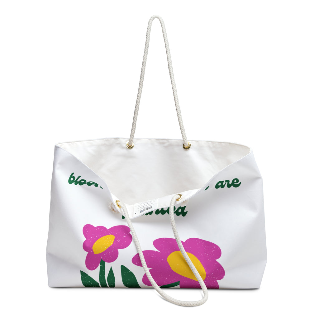 opening of White tote bag with pink flowers and green text on a white background