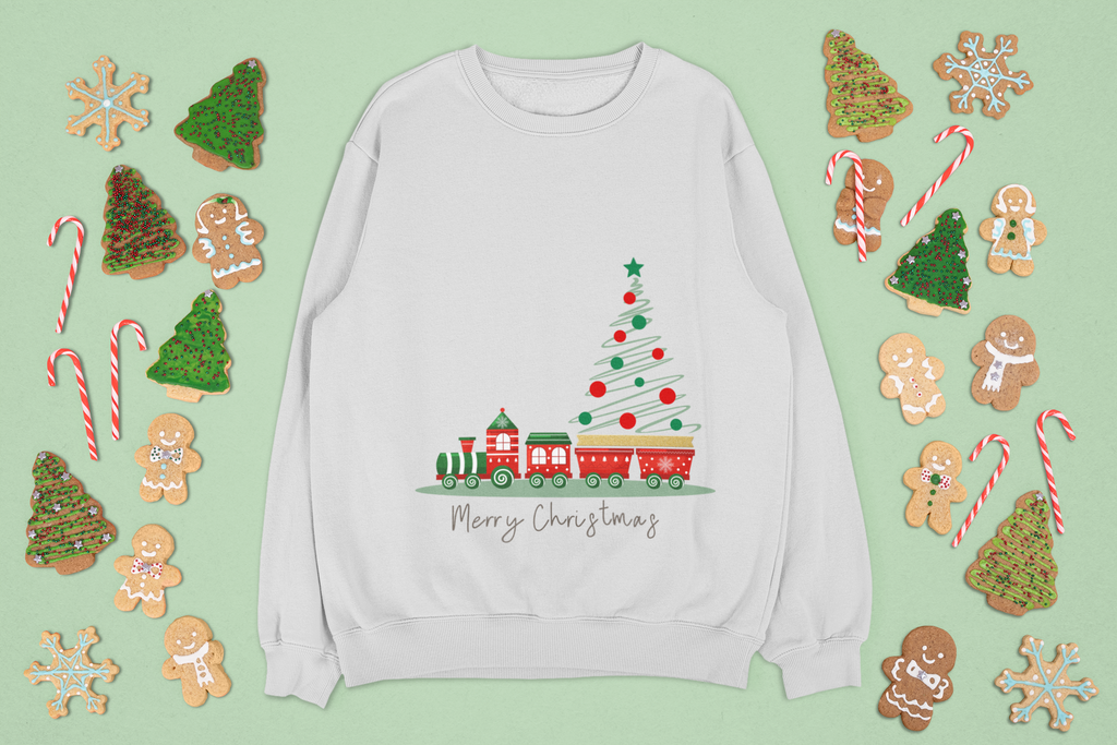 gray sweatshirt with Christmas tree and train design, surrounded by festive cookies and candy on a light green background