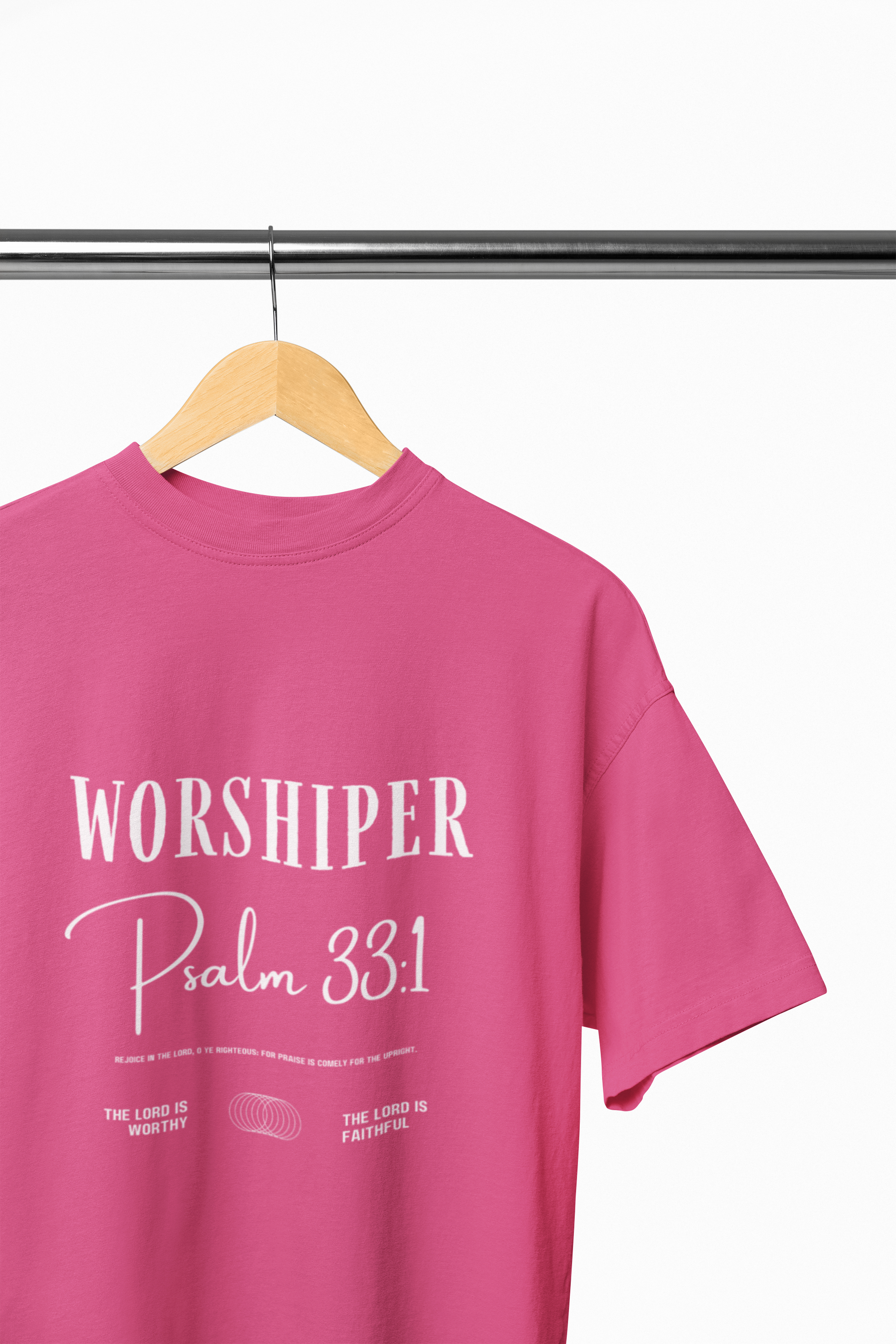 Pink t-shirt with 'Worshiper Psalm 33:1' text on a hanger against a white background