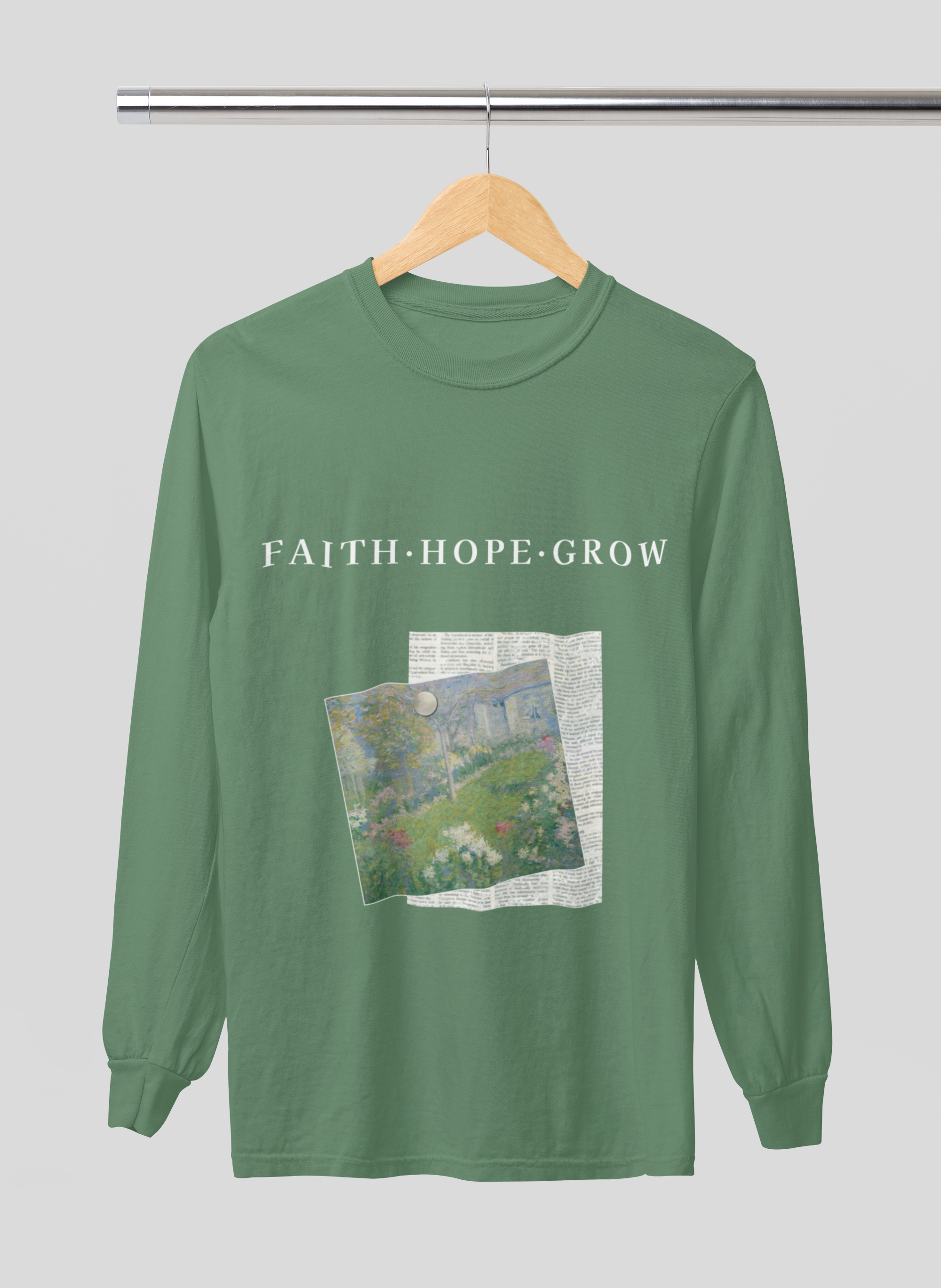 Green long-sleeve shirt with 'FAITH HOPE GROW' text and a graphic on a hanger against a gray background