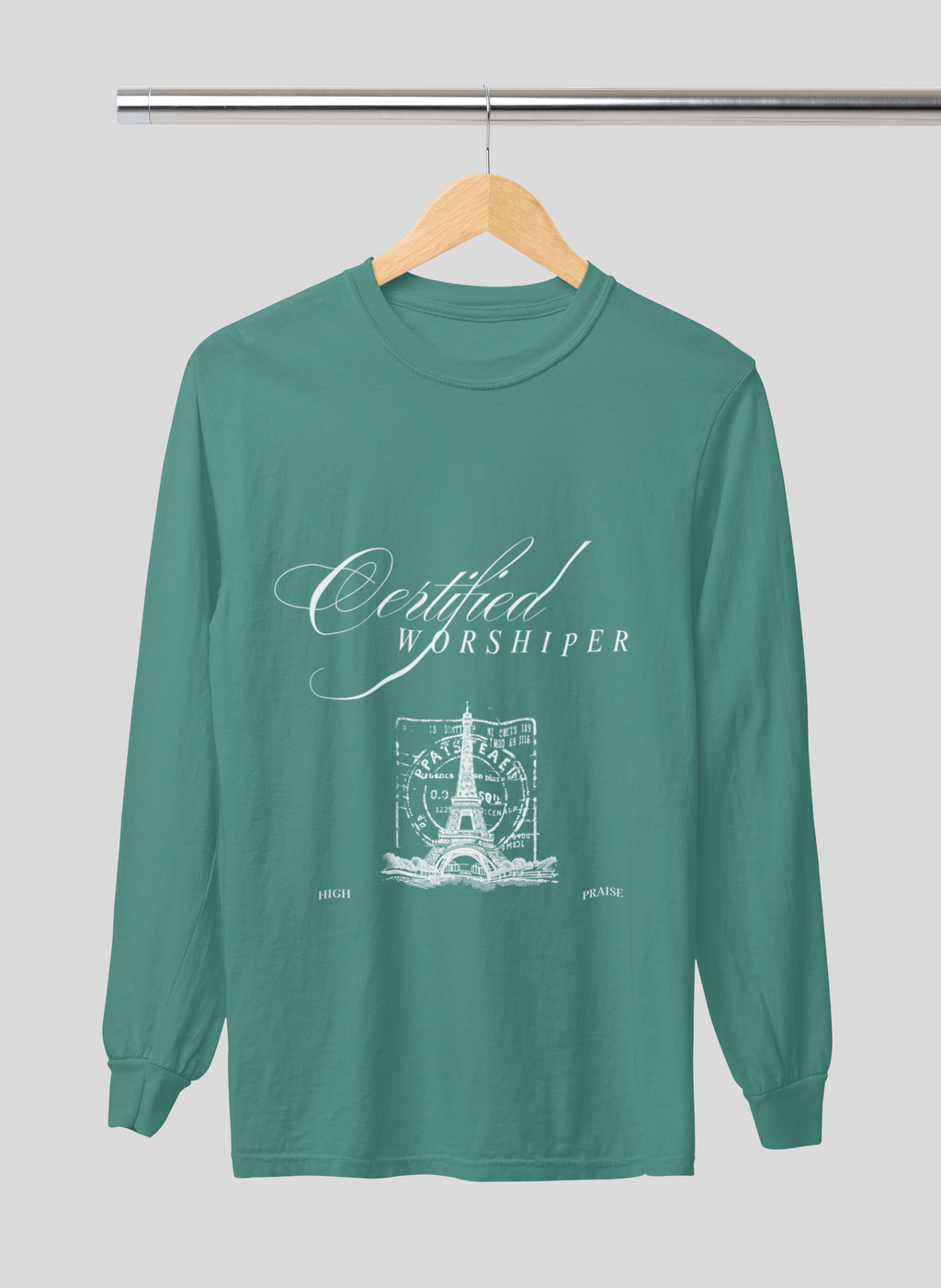 Green long-sleeve shirt with 'Certified Worshipper' text on a hanger against a gray background