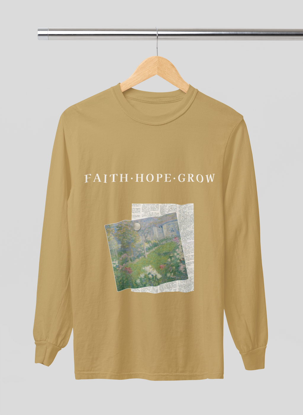 mustard yellow long-sleeve shirt with 'Faith Hope Grow' text and nature graphic on a hanger against a light gray background