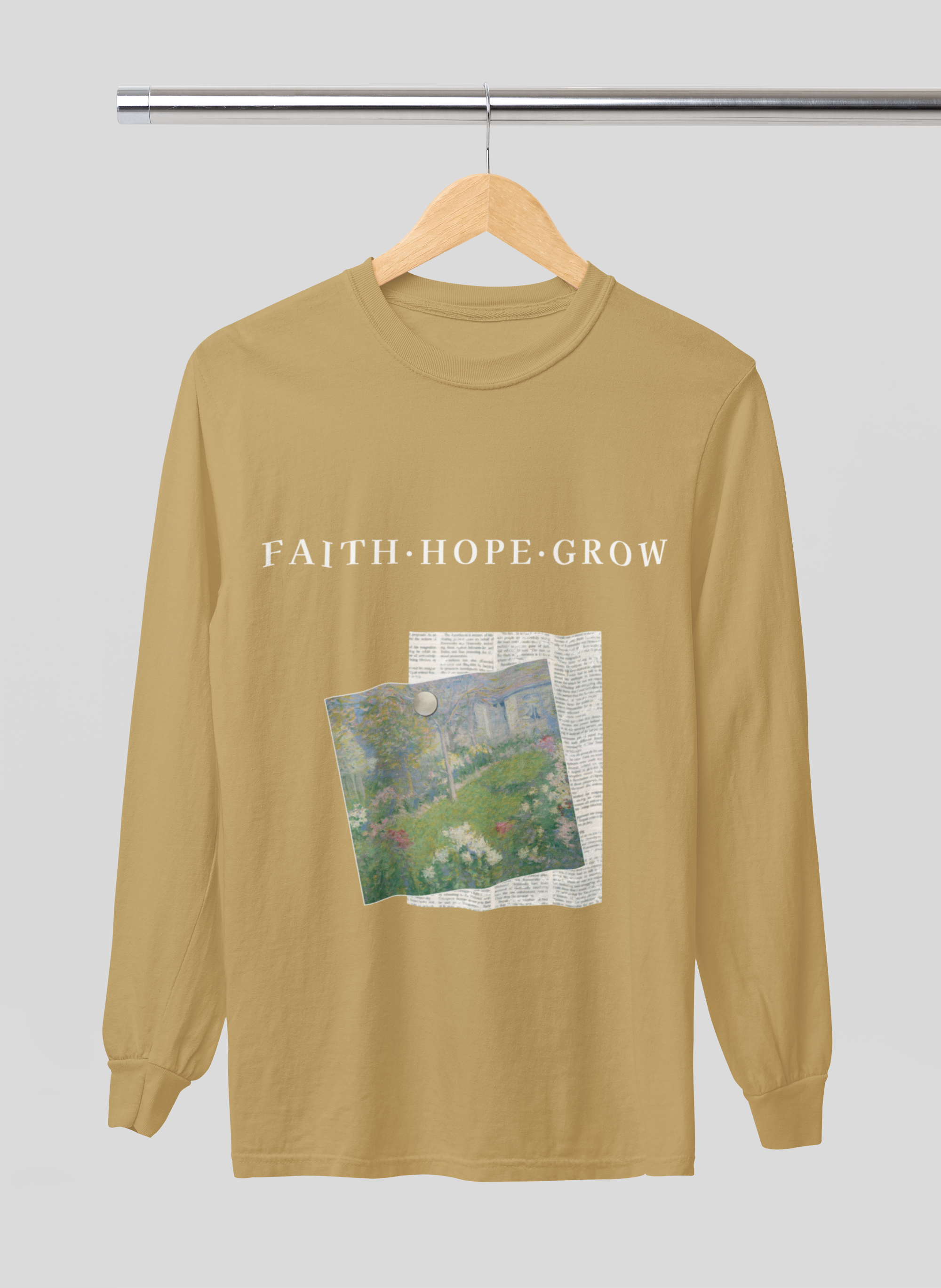 mustard yellow long-sleeve shirt with 'Faith Hope Grow' text and nature graphic on a hanger against a light gray background
